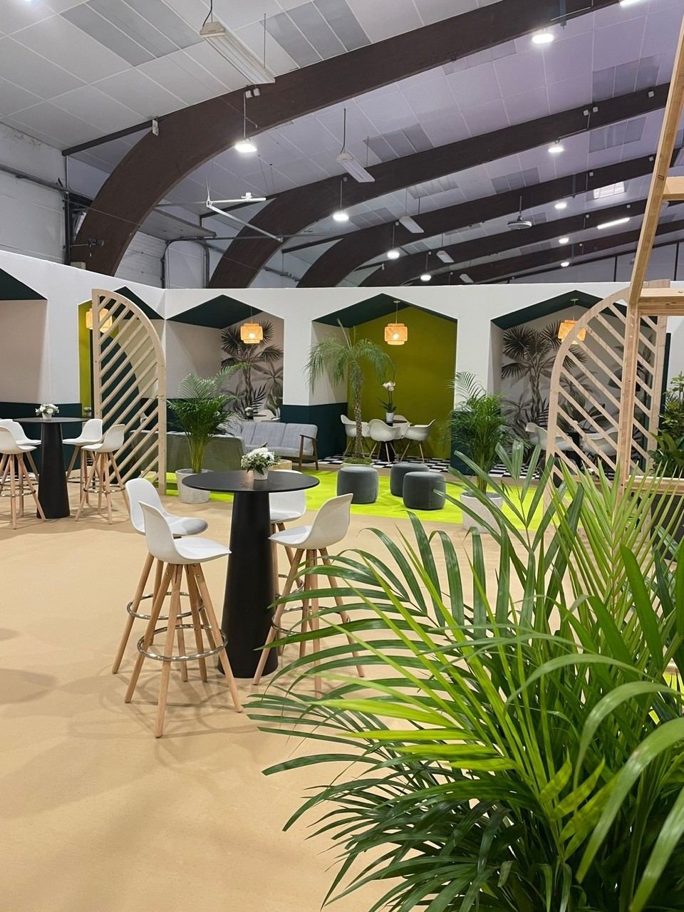 Espace lounge VIP végétalisé avec mange-debout sur un salon professionnel
