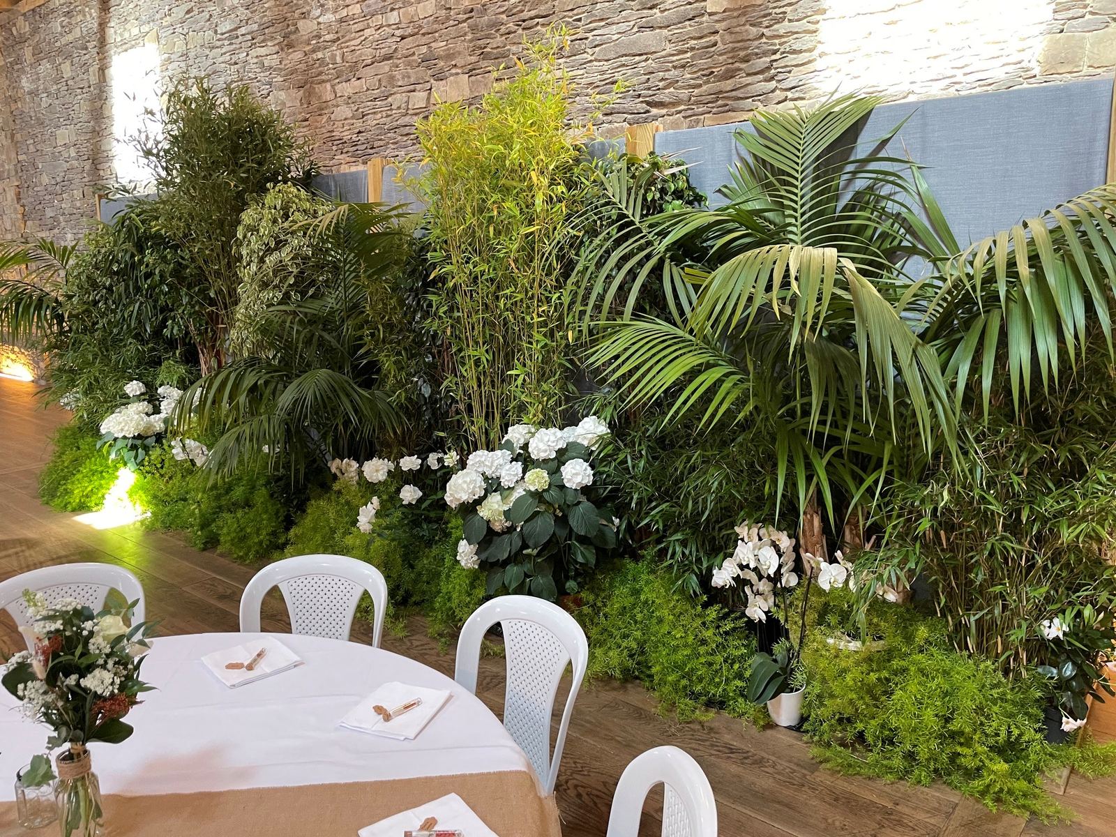Mur végétal fleuri en pierre naturelle pour un mariage, avec hortensias et orchidées blanches