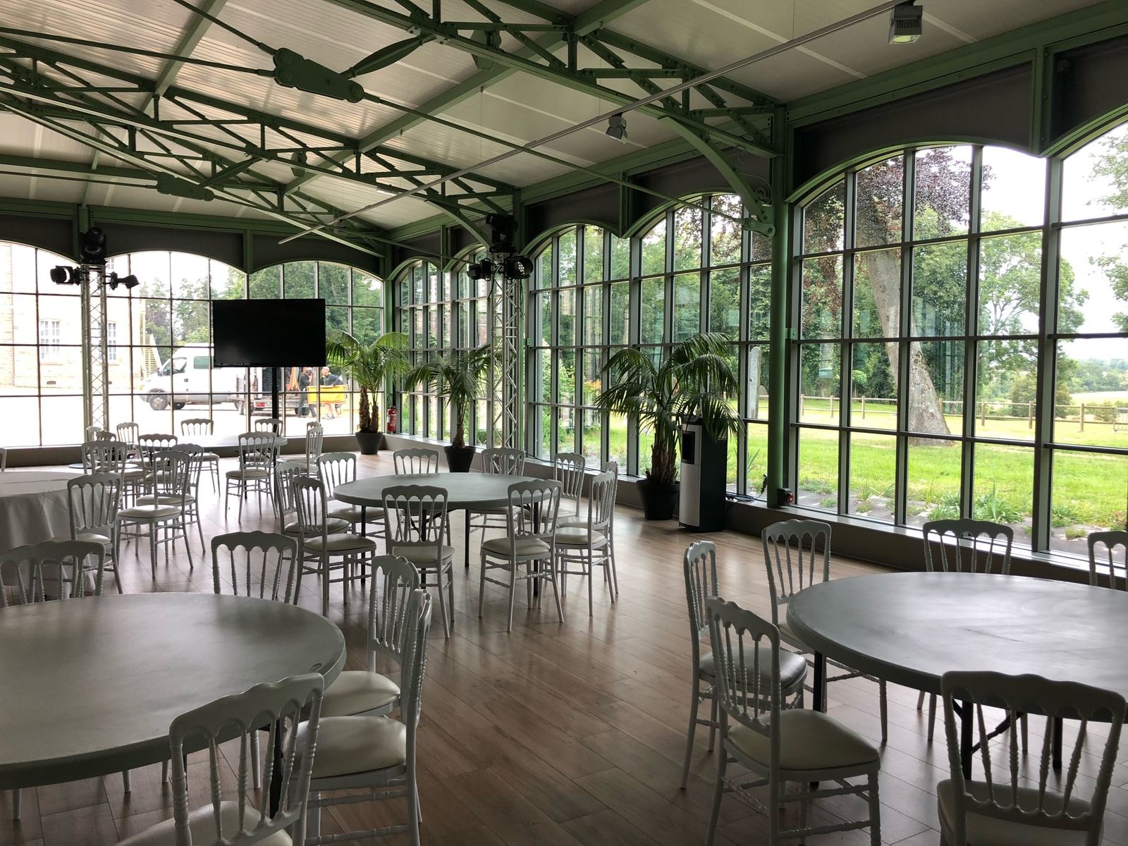 Salle de réception de mariage végétalisée avec palmiers, verrière